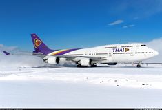 a large jetliner sitting on top of an airport tarmac covered in lots of snow