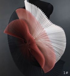 an umbrella that is sitting on top of a black stand with red and white fan attached to it