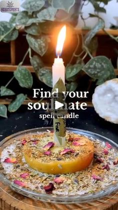 a candle that is sitting on top of a cake with flowers and leaves around it