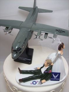 a wedding cake topper with a bride and groom in front of an airplane