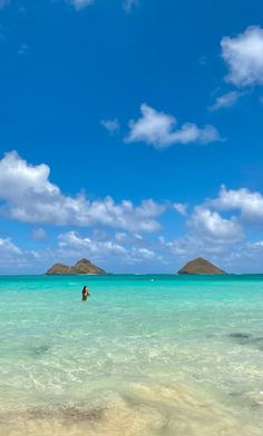 a person in the ocean with an island in the background