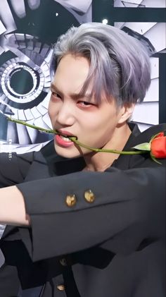 a man with grey hair holding a rose in his hand