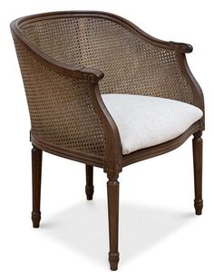 a brown chair with a white cushion on the back and armrests, in wicker