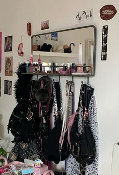 several purses are hanging on a rack in front of a mirror and other items