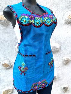 a mannequin wearing a blue top with colorful flowers on it's chest