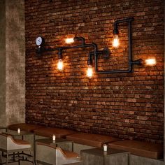 a brick wall with lights on it and some stools in front of it,