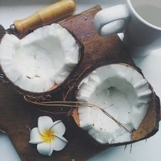 two pieces of coconut on a cutting board next to a flower