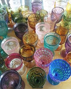 many different colored glass cups are on the table and ready to be filled with them