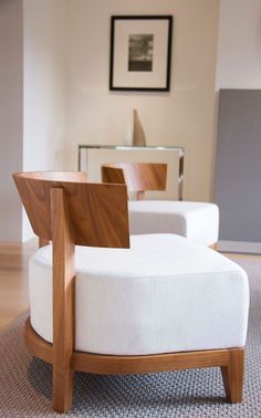 a white chair sitting on top of a rug next to a wooden table and chairs