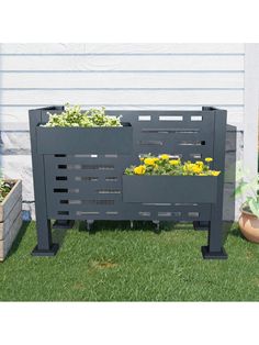 an outdoor planter made out of pallets with flowers growing in it on the grass