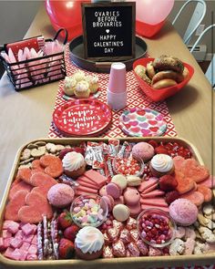 two trays filled with valentine's day treats on a table