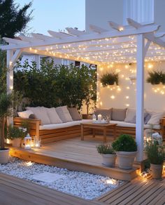 an outdoor deck with lights and potted plants