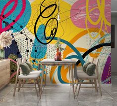 an artistic wall mural in a dining room with chairs and a table next to it