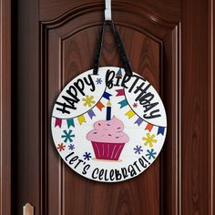 a happy birthday sign hanging on a door with a cupcake and stars around it