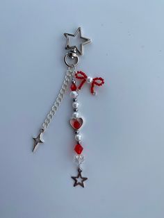 a red and white beaded keychain with stars, pearls and beads on it