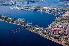 an aerial view of a large body of water with buildings and bridges in the background