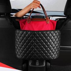 a woman holding a red purse in the back seat of a car with her hand on it