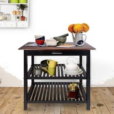 a kitchen island with pots, pans and other items on it in front of a white wall