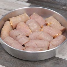 raw chicken in a metal bowl on a wooden table