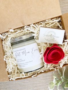 an open box containing a candle and a rose