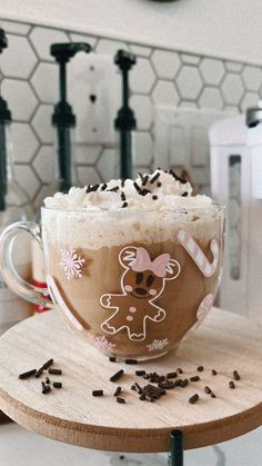 a cup filled with whipped cream and chocolate sprinkles on top of a wooden table