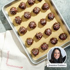 a pan filled with chocolate covered donuts on top of a counter next to a napkin