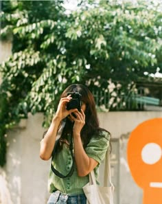 a woman holding a camera up to her face