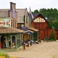 an old western town with lots of wooden buildings and flags on the side of it