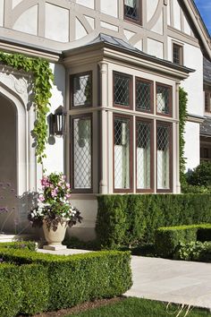 a large white house with hedges in front of it