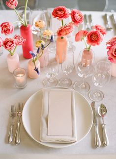 the table is set with pink flowers and silverware