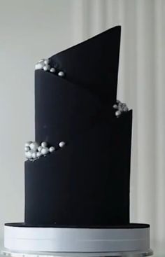 a black and white wedding cake with pearls on it