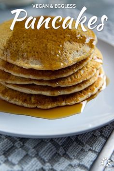 a stack of pancakes sitting on top of a white plate with syrup drizzled over them