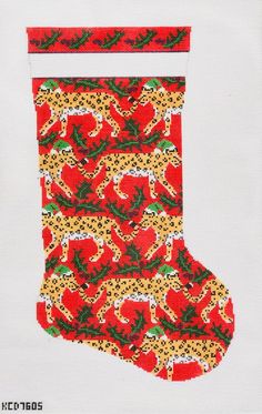 a cross stitch christmas stocking with leopards and red bell peppers on white background