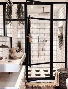 a bathroom with black and white tiles on the walls, flooring and shower stall