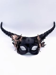 Step into the realm of mystical enchantment with our women's longhorn masquerade mask adorned with a blend of gold and black with forest leaves, Snake and moss. This mask captures the essence of mythical creatures and the allure of nature, infusing your look with a touch of majesty and forest-inspired allure. Age Group/Gender - Adult/Women Size/Type - One size fits all adults Mask Color - Black and gold Mask Material - Polyresin Accent Material - Paint Special Features - Forest leaves and moss Black And Gold Mask, Horned Mask, Forest Sprite, Mardi Gras Kid, Kids Party Packs, Long Horns, Forest Leaves, Red Forest, Mask Ideas