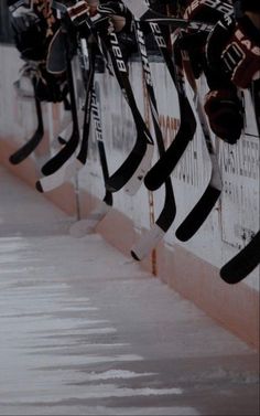 hockey sticks are lined up against the wall