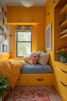 a bedroom with yellow painted walls and built - in storage units, including a window seat