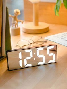 an alarm clock sitting on top of a wooden desk