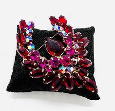 Gorgeous large vintage ruby red and pink rhinestone brooch. Silver tone metal securely prong set with ruby red rhinestones,magenta pink and AB pink rhinestones. In excellent vintage condition with minimal age appropriate wear. Measures 3 1/2 inches tall by 2 1/2 inches wide. Roll over clasp secure. Beautiful!! Formal Ruby Brooch Jewelry, Red Costume Jewelry Brooch, Vintage Red Rhinestone Jewelry, Red Retro Brooch Jewelry, Antique Red Brooch, Vintage Designer Jewelry, Magenta Pink, Red Rhinestone, Rhinestone Brooches