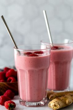 two glasses filled with raspberry smoothie on top of a table