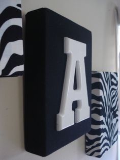 the letters are made out of black and white paper with zebra print wallpaper behind them