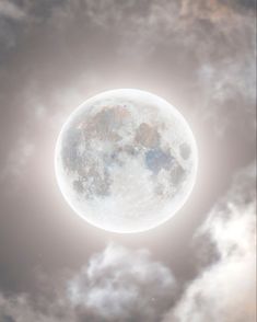 the full moon is seen through clouds in this artistic photo, it appears to be very bright