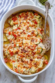 a casserole dish with zucchini, tomatoes and other vegetables in it