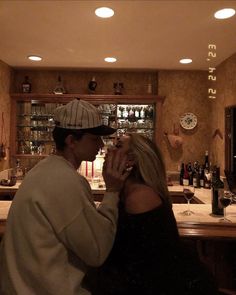 a man and woman standing in front of a bar