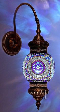 a blue and white mosaic light hanging from a wall