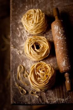 three pastas and a rolling pin on a wooden table