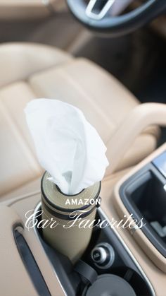 the interior of a car with a tissue dispenser and cup holder in it