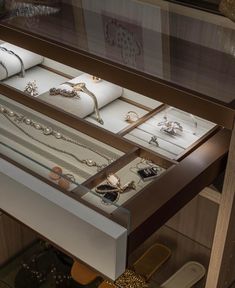 an open drawer with jewelry inside of it