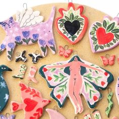 decorated cookies are arranged on a plate with pins and magnets in the shape of animals