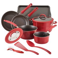 an assortment of red pots and pans with utensils